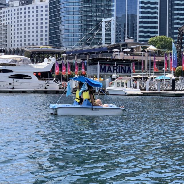 Couple rides pedal boats at Cockle Bay Wharf